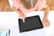 © Syda Productions - children, education and technology concept - close up of little student girl using tablet computer at home from top