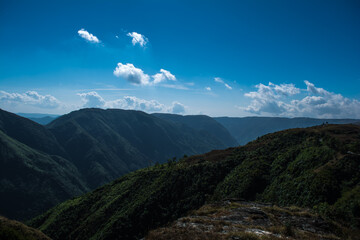 Wall Mural - Natural view of the folded mountains and lush green valleys with clear sky and clouds of Cherrapunji, Meghalaya, North East India
