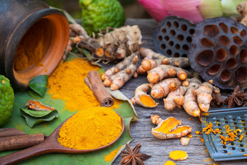 Wall Mural - Turmeric powder,Turmeric fresh and ingredient herbs on wooden background