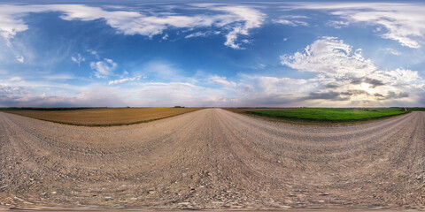 Wall Mural - full seamless spherical hdri panorama 360 degrees angle view on no traffic gravel road among fields in evening with cloudy sky in equirectangular projection, ready for VR AR virtual reality content