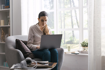 Wall Mural - Woman connecting with her laptop at home