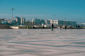 the daily life of different people at the Hassan II Mosque in Casablanca, the pray, talk, and spent time together on a normal summer day.  The mosque has unique and Arabic doors and towers
