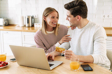 Poster - Portrait of happy couple using laptop and holding credit card