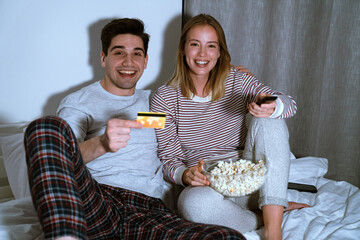 Wall Mural - Portrait of couple using cellphone and holding card while watching tv