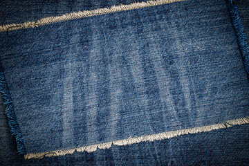 destroyed torn denim blue jeans fabric frame on blue jeans background. worn jeans casual double colo