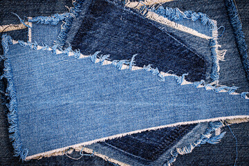 destroyed torn denim blue jeans fabric frame on blue jeans background. worn jeans casual double colo