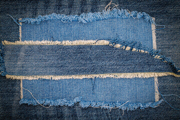 destroyed torn denim blue jeans fabric frame on blue jeans background. worn jeans casual double colo
