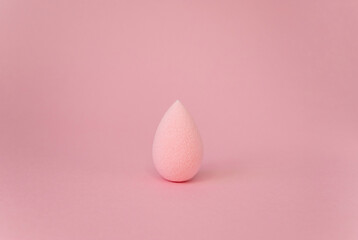 Pink beauty blender isolated on pink background with copy space. Pink blending sponge for makeup. Minimal think. Minimal thing