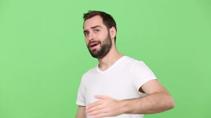 Wall Mural - Bearded young guy 20s in white t-shirt isolated on green chroma key background studio. People emotions lifestyle concept. Looking at camera waves his hand invites you to go with him come on hurry up