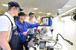 © industrieblick - young apprentices in technical vocational training are taught by older trainers on a cnc lathes machine