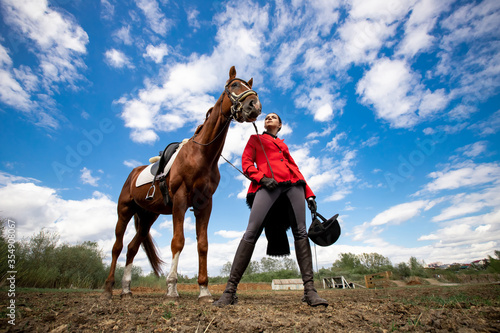 Fotografía Portrait Jockey woman rider with brown horse, concept advertising equestrian clu
