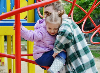 Mother holding daughter on a playground