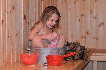 A child in a Russian bath in a steam room. Water treatments for a healthy body