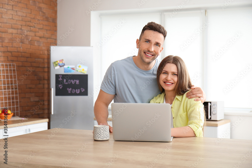 Young woman with laptop in kitchen