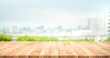 Real wood table top texture on blur leaf tree garden and wall building from city,park background