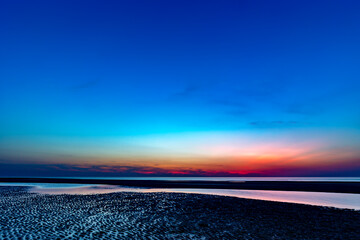 Wall Mural - Colourful sky over the north sea after sunset at the beach on Juist, East Frisian Islands, Germany.