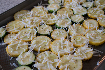 A side dish of sliced yellow squash and zucchini roasted in the oven and covered in Parmesan cheese.