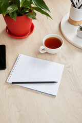 Wall Mural - green plant, cup of tea and blank notebook with pencil on wooden surface