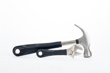 a hammer and a spanner with black rubber handle isolated on white background