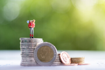 Miniature people: Group of backpacker stack of coin on calendar using as business trip traveler adviser agency or explorer on earth background concept.