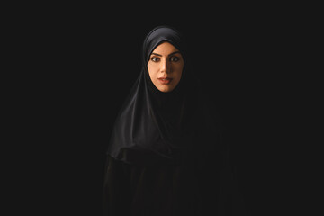 Wall Mural - Beautiful muslim woman looking at camera isolated on black