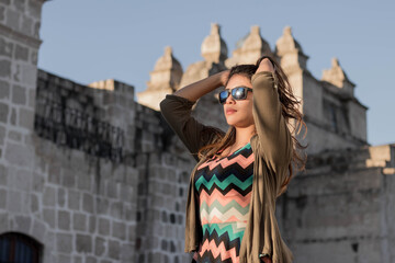 Mujer posando con gafas de sol al atardecer