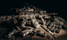 Military Assault Rifle Laying On Table With Tactical Gear Accessories, Knife, Gun And Gloves.