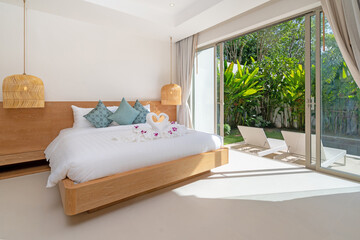 Wall Mural - Interior design of bedroom in luxury and modern style pool villa feature a pool view, green garden, sunbed or sunlounger on pool terrace,  blue cushion on bed and hanging lamp and sliding door