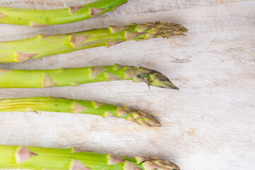 Wall Mural - fresh bunch of organic green asparagus spears on wooden table