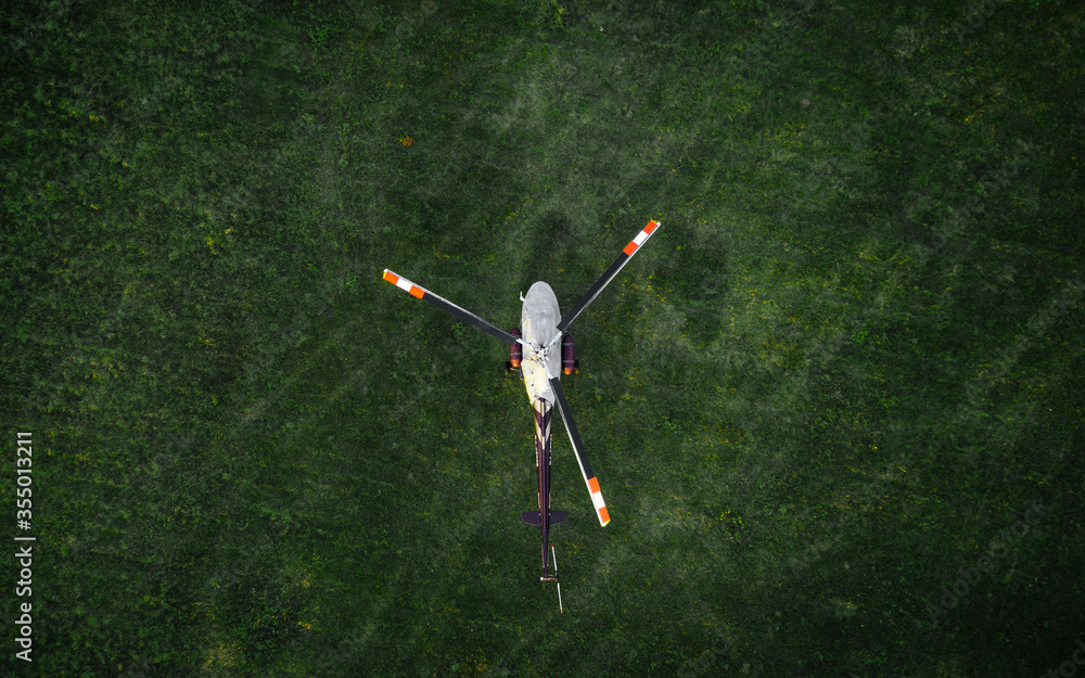 helicopter on the green grass photographed from the air - obrazy, fototapety, plakaty 