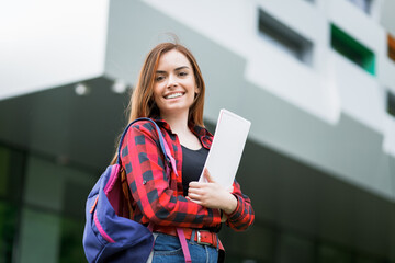 Portrait of a young girl student on the background of a university campus