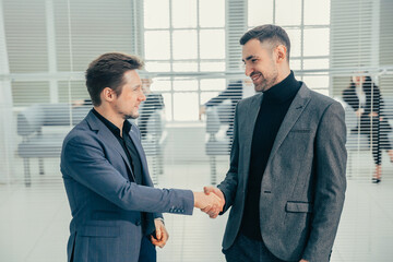 business people shaking hands standing in the office lobby.