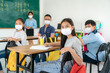 © ake1150 - Group of Asian elementary school students and teacher wearing hygienic mask to prevent the outbreak of Covid 19 in classroom while back to school reopen their school