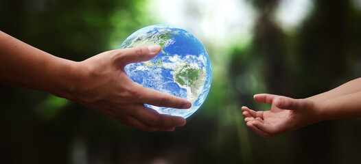 Wall Mural - concept - hands of adult giving planet earth to child - elements of this image furnished by NASA