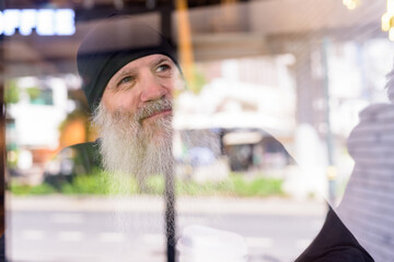 Sticker - Face of mature handsome bearded hipster man thinking at the coffee shop through the window