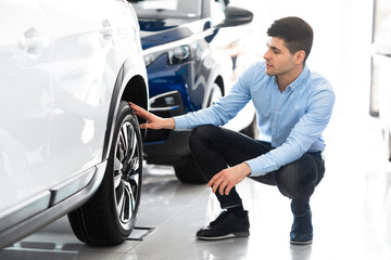 Man checking car wheel rims and tire