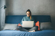 © franz12 - Girl working on laptop from home or student studying from home or freelancer. Or she is watching a video or using the Internet
