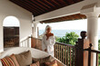 © Yevhenii - Woman in white  bath robe looking at beautiful ocean view from a tropical balcony with morning coffee. towel over the head