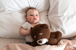 © speed300 - Cute, beautiful little girl lying on the bed with a teddy bear