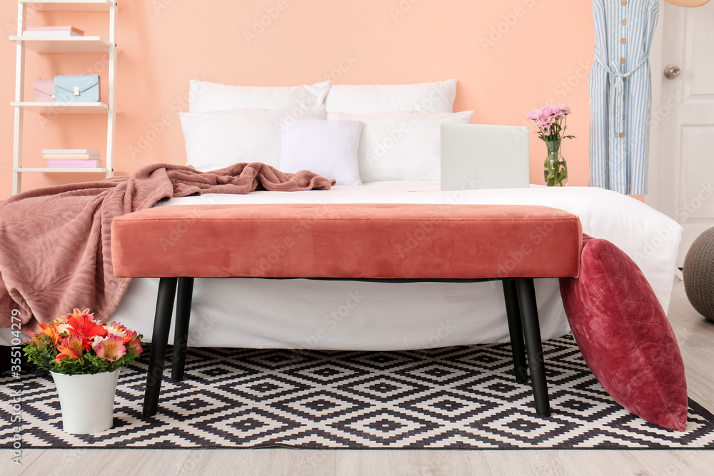 Stylish interior of room with bed and bench
