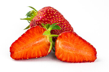 two strawberries on the white background one strawberry whole the other is cut into two halves