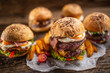 © weyo - Selection of various fresh tasty burgers with potato wedges in a rustic environment