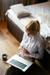 © JustLife - Young businesswoman working on lap top. Beautiful woman working in hotel room.