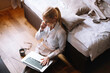 © JustLife - Young businesswoman talking to the phone in hotel. Beautiful woman working in hotel room.