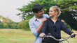 © calcassa - young couple riding a bicycle in the park.