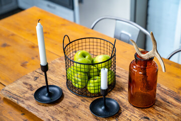 Wall Mural - apples and candles a wooden table. kitchen in a Scandinavian style. 