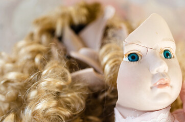 Portrait of a broken doll face with long blond hair