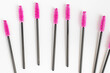 Cosmetic brushes for eyelashes and eyebrows on a white background. Pink combs for eyelash extensions. Top view.