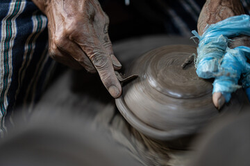 male potter is making a vase from clay, selective focus.