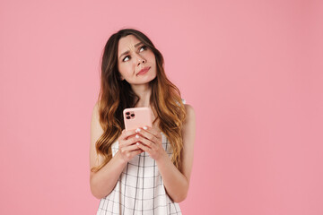 Canvas Print - Image of confused cute woman using cellphone and looking aside